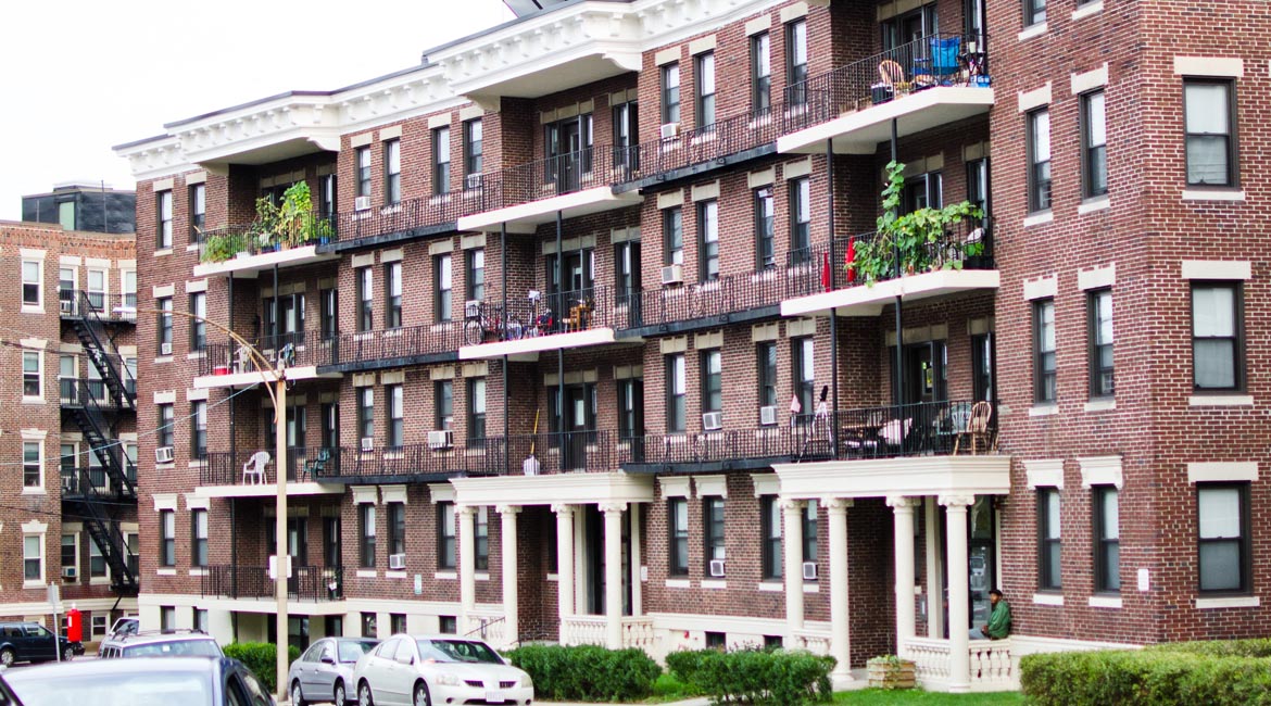 Four story brick apartment building with balconies